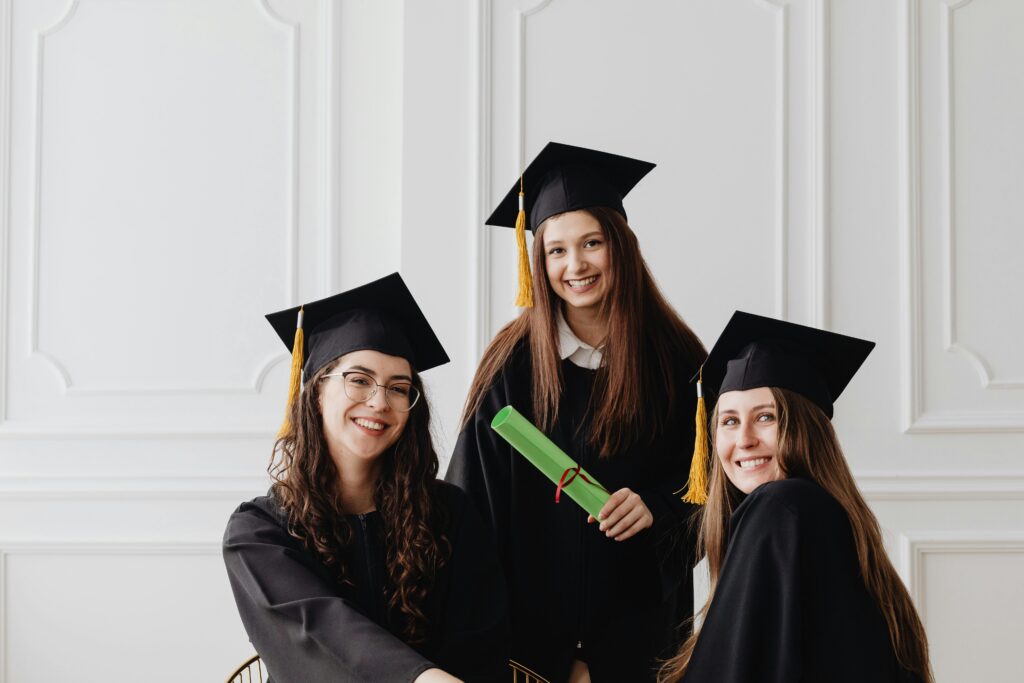 A group of recent graduates smiling while holding their diplomas