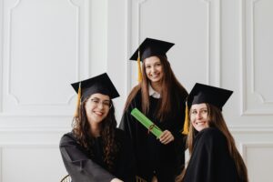 A group of recent graduates smiling while holding their diplomas